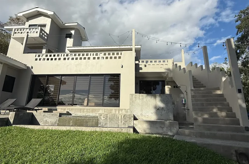 Exterior de tres pisos y césped de Casa Cerca del Cielo en Rancho Santana