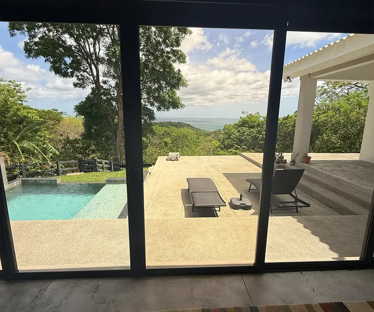 Puertas corredizas en la sala de estar que dan a la piscina y a la vista, Casa Cerca del Cielo