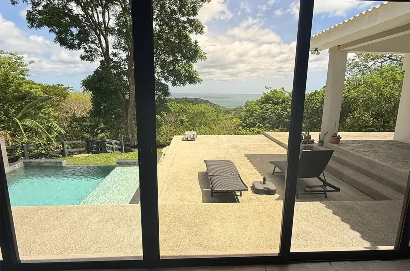 Puertas corredizas en la sala de estar que dan a la piscina y a la vista, Casa Cerca del Cielo