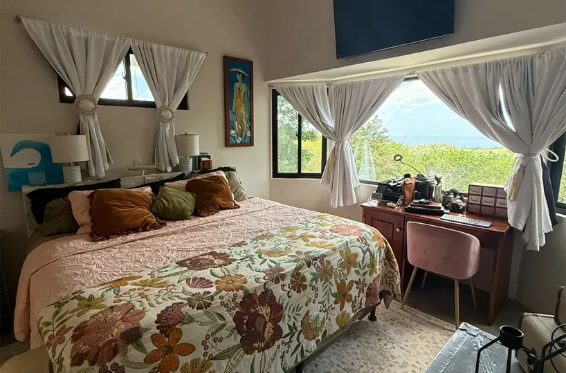 Dormitorio principal con ventanas con vista al jardín y al océano, Casa Cerca del Cielo